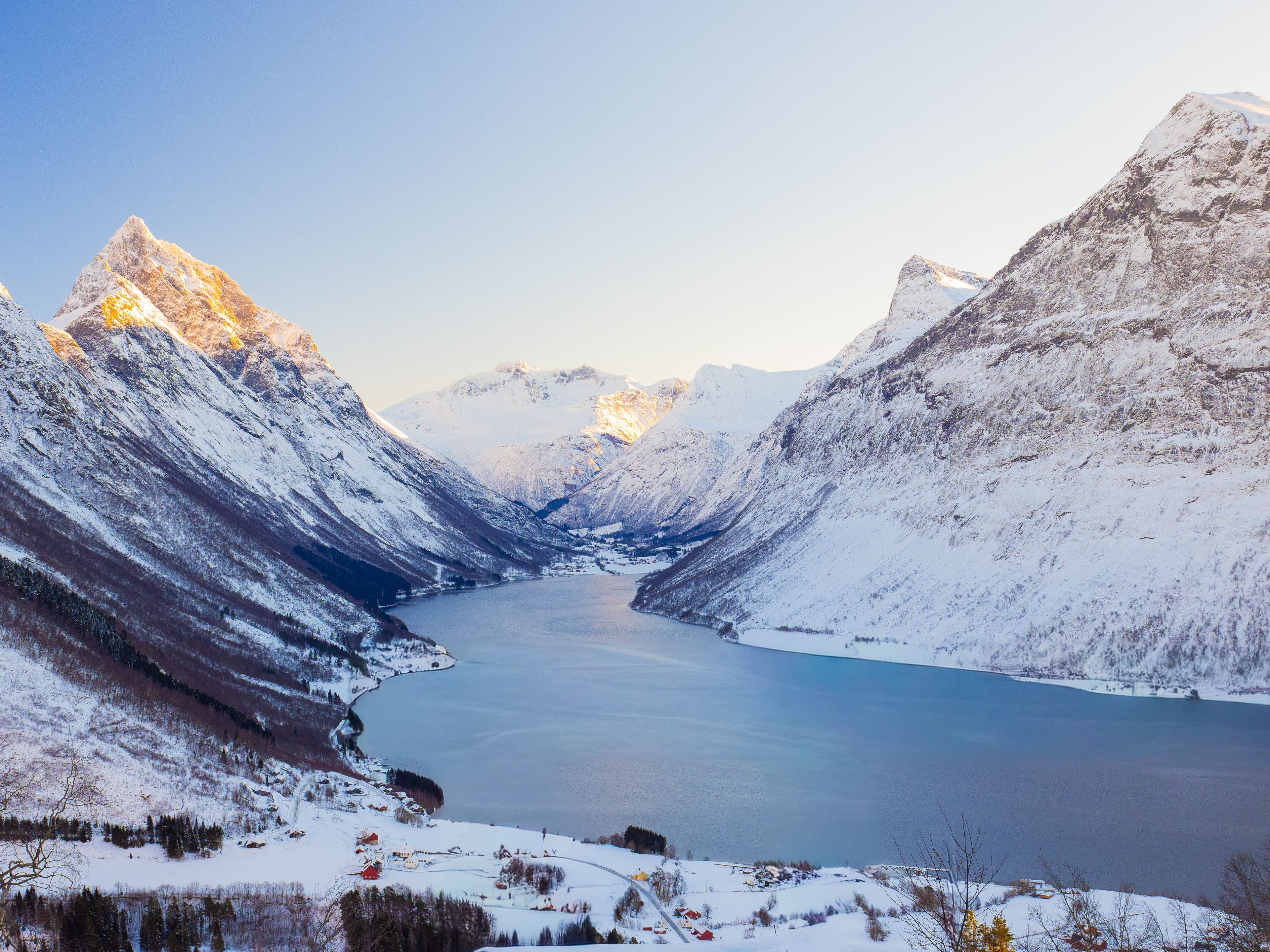 Fotografie eines Fjordes m Winter mit schneebedeckten Bergen