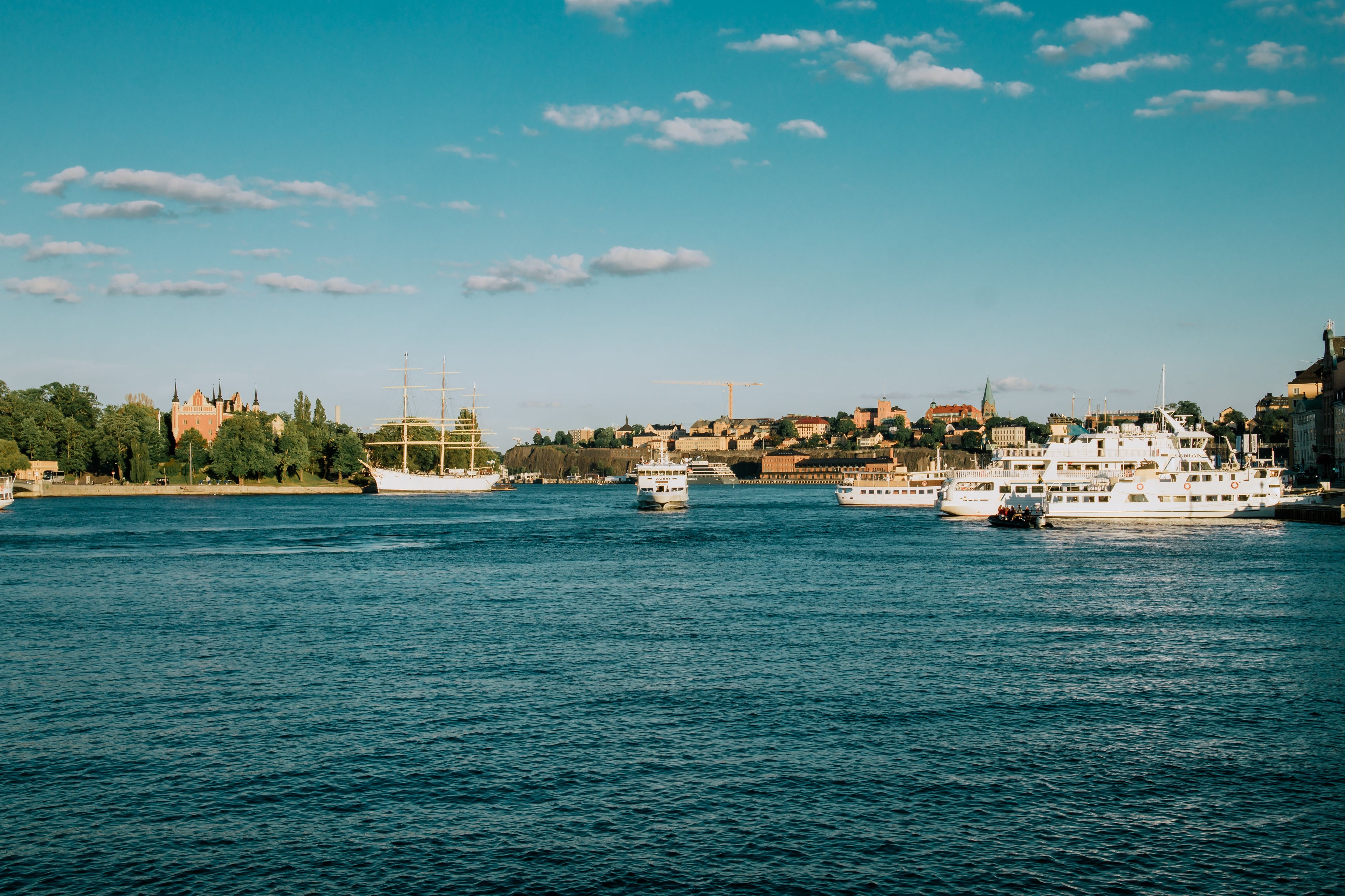 Bild, das Schiffe auf dem Wasser vor der Stadt von Stockholm zeigt.