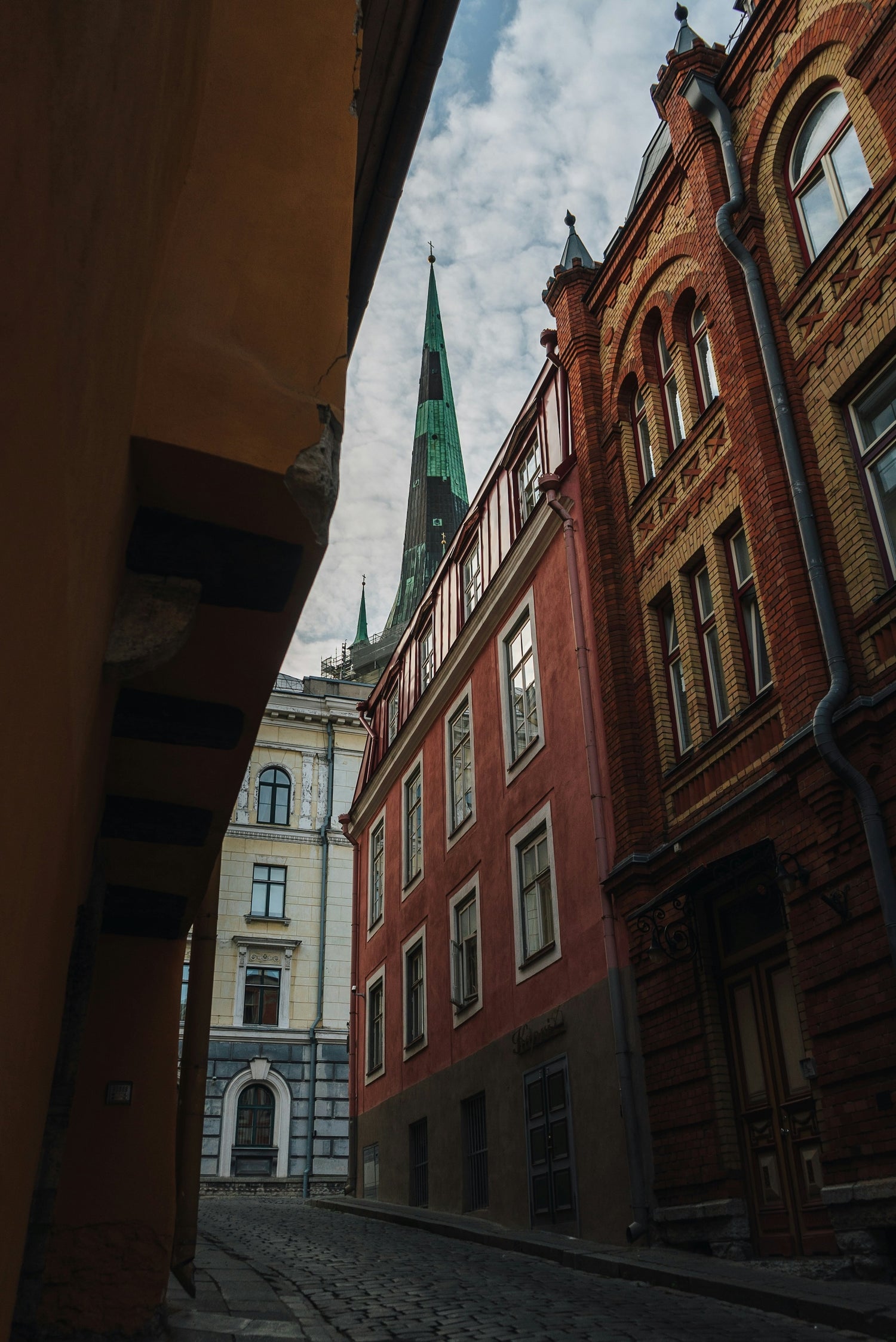 Bild, dass die Altstadt von Tallin aus der Froschperspektive zeigt. Zu sehen ist ein gutes historisches Gebäude und ein Kirchturm.