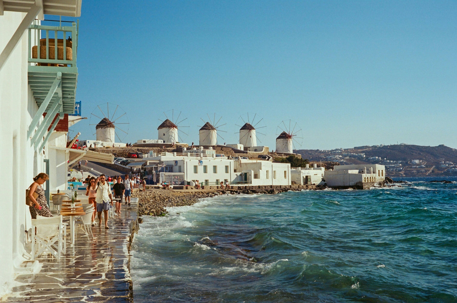 Windmühlen von Mykonos über weißen Häusern und blauem Meer
