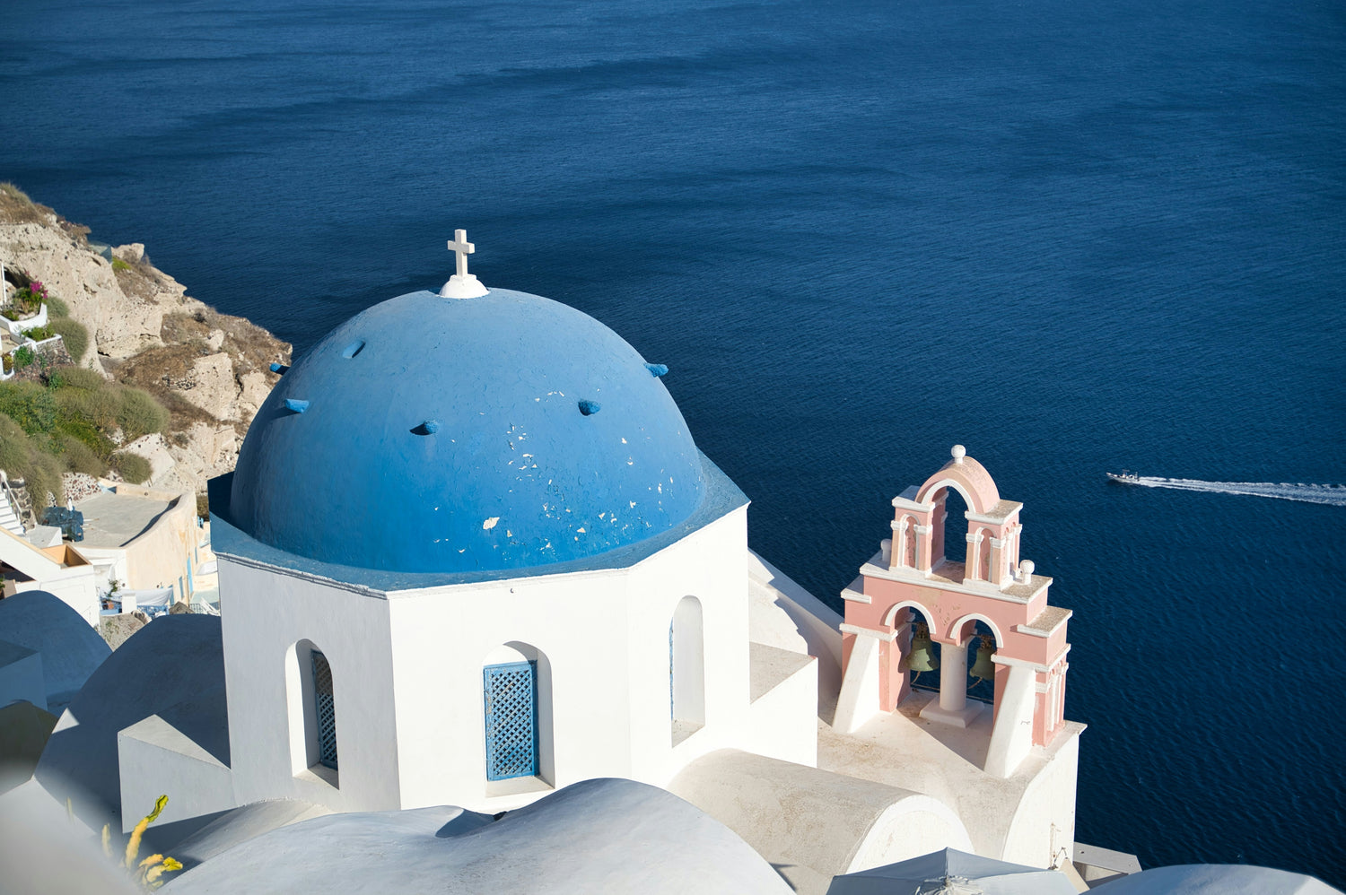 Weiße Häuser und blaue Kirchenkuppeln in Oia über der Caldera