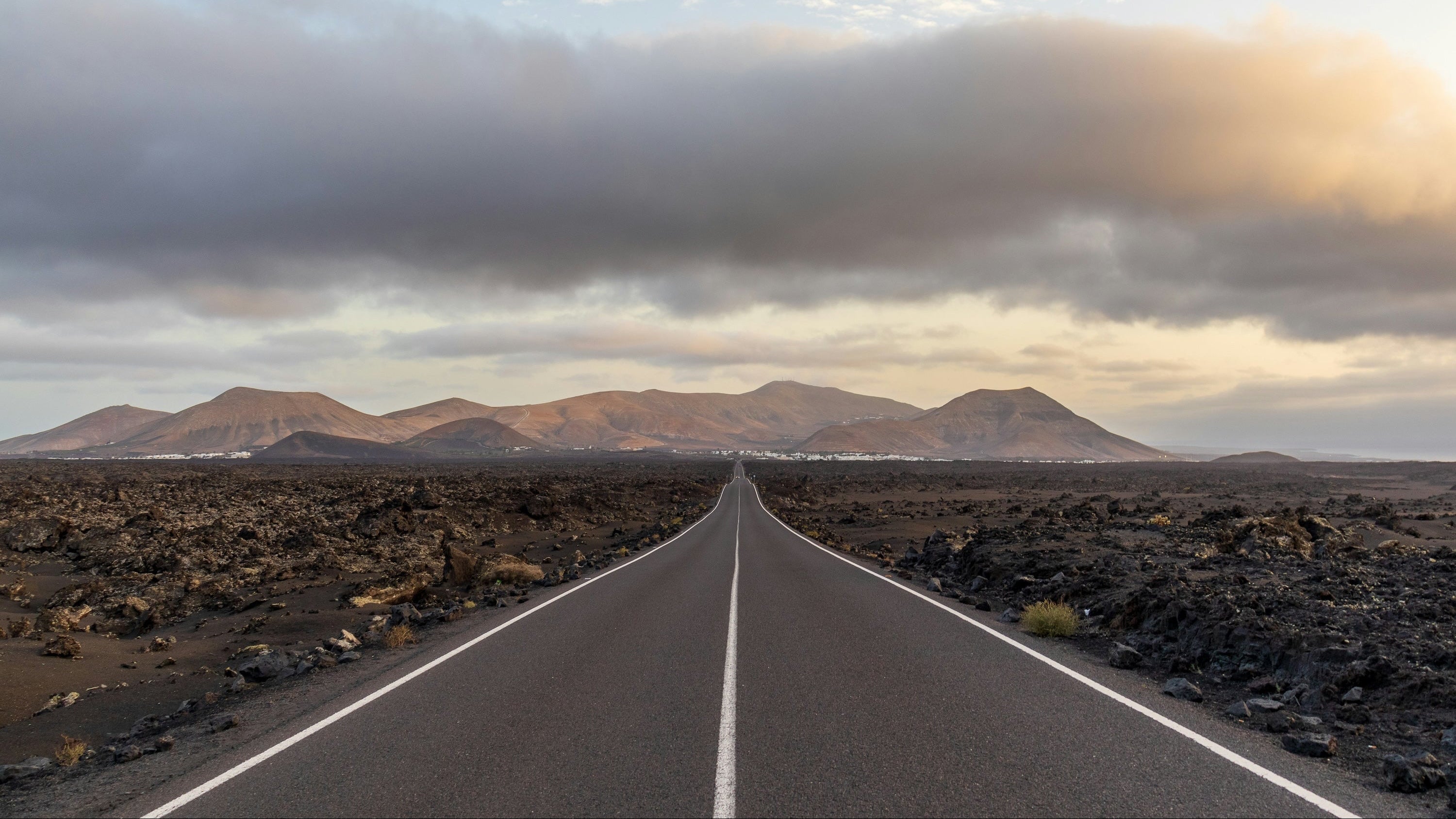 Straße zwischen dunklen Vulkankegeln im Timanfaya-Nationalpark